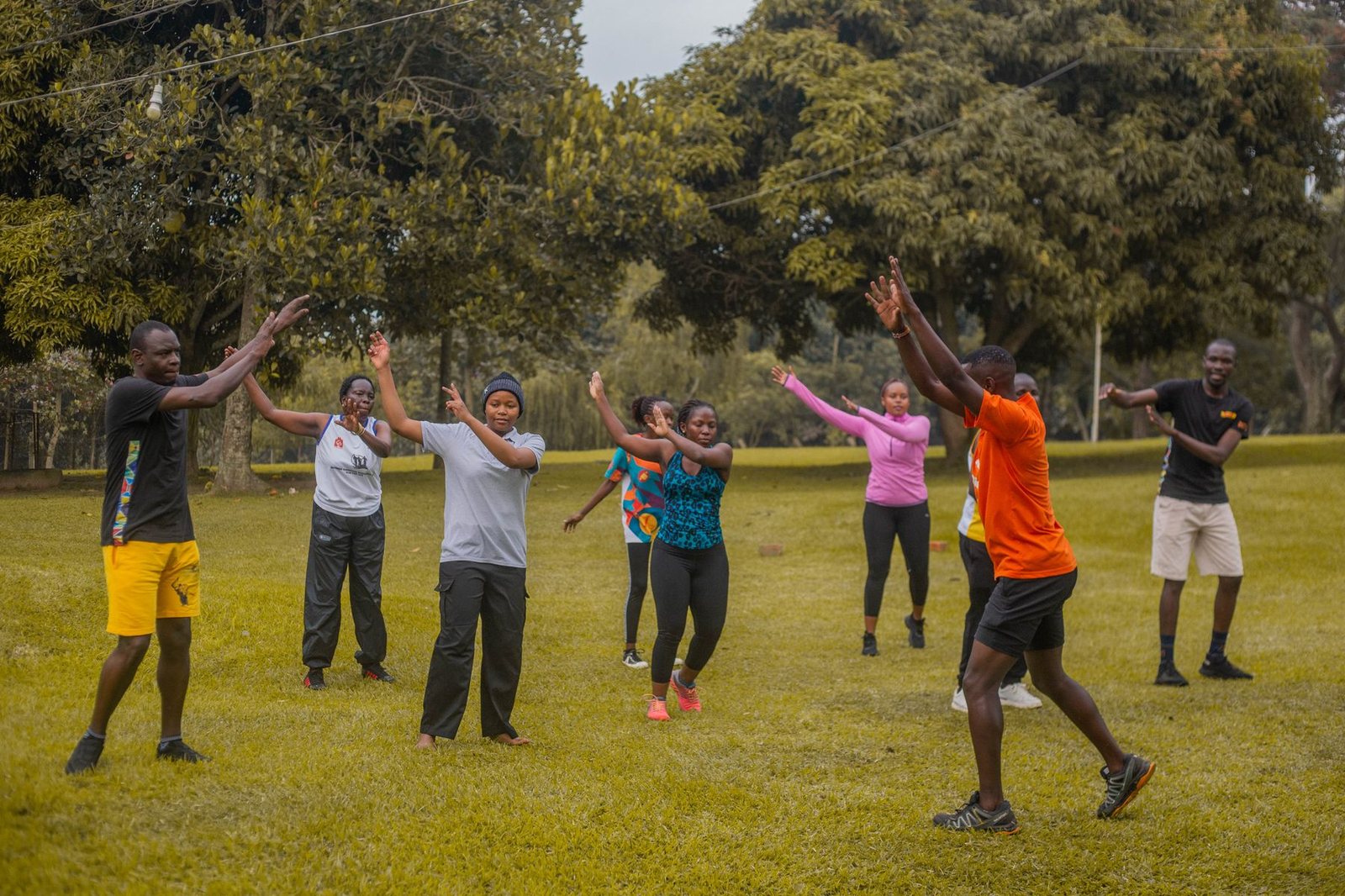 Adults exercising together outdoors in a park